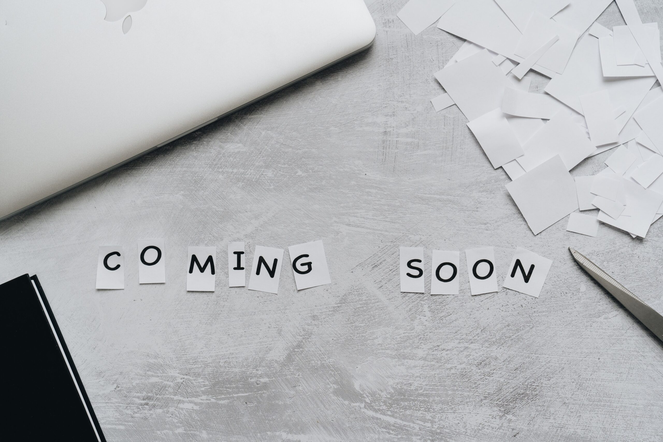 Home A creative arrangement with paper cutouts spelling 'Coming Soon' on a textured surface.